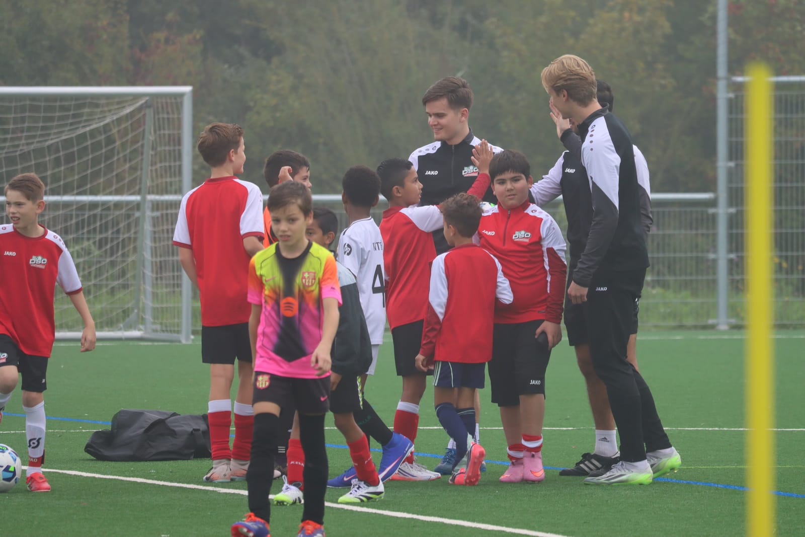Een trainer geeft een speler een high-five tussen de andere spelers
